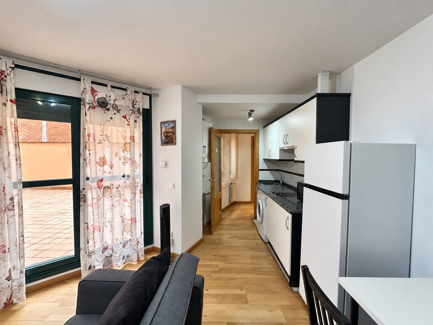 Salón con sofá cama y cocina abierta de Cinco de Copas
